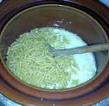 slow cooker with ingredients for mac and cheese