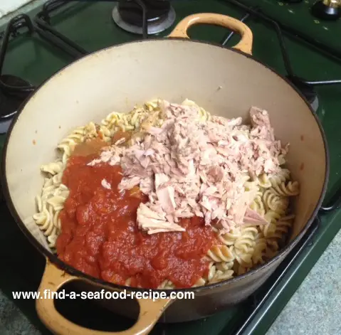 mixing sauce with pasta and tuna